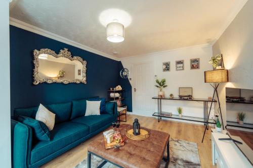 a living room with a blue couch and a table at 2 Bedroom Peaceful Home, Colchester in Mile End