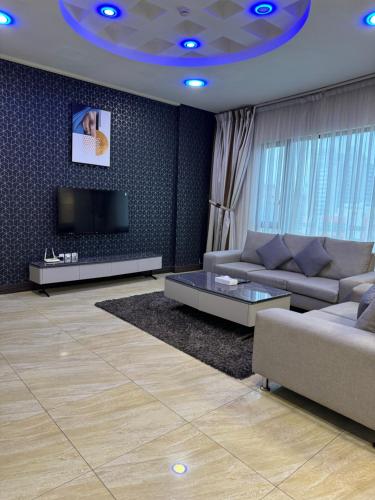 a living room with a couch and a tv at Amfas Suites أمفاس سويتس in Manama