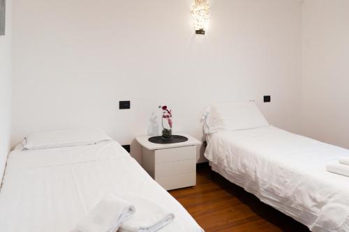 two beds sitting next to each other in a bedroom at 5min RhoFiera-10minMetro-Parking in Pero