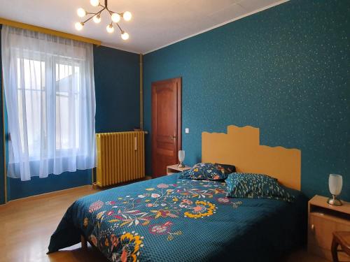sypialnia z łóżkiem z niebieską ścianą w obiekcie Charmante maison rénovée avec jardin, proche de Verdun, idéale pour familles, draps et chauffage inclus - FR-1-585-50 w mieście Sivry-sur-Meuse