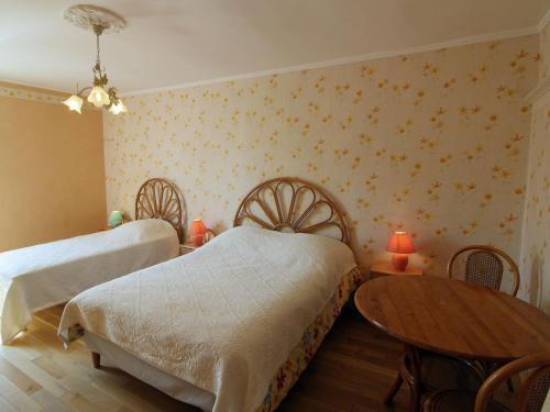 een slaapkamer met 2 bedden en een houten tafel bij Gîte Bellefontaine, 6 pièces, 12 personnes - FR-1-589-40 in Bellefontaine