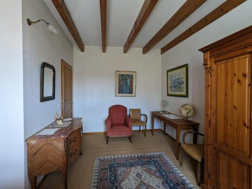 a living room with a red chair and a desk at Gîte Saint-Amand-sur-Ornain, 4 pièces, 6 personnes - FR-1-585-56 