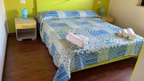 a bedroom with a bed with towels and slippers on it at Beach Apartments Poseidon in Casa dello Stumio