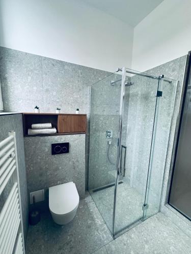 a bathroom with a toilet and a glass shower at Apartmány Ružomberok in Ružomberok