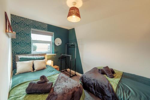 a bedroom with green walls and a bed and a window at 2 Bedroom Peaceful Home, Colchester in Mile End
