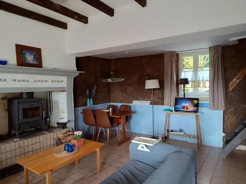 a living room with a blue couch and a table at Gite Bleu in MÃ©nil-Vin