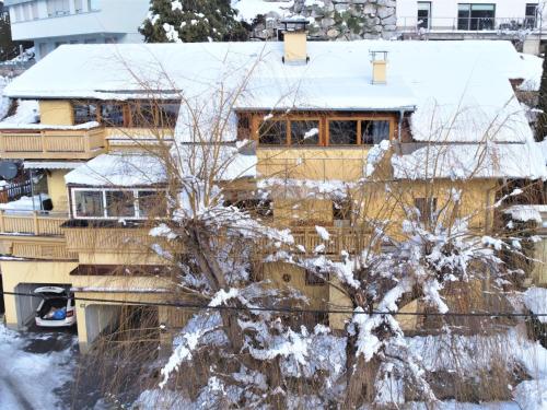 a house covered in snow with a tree at Apartment Hannelore by Interhome in Omes