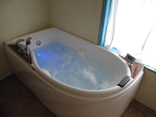 uma banheira na casa de banho com uma janela em Villa Rustica em Pomoshtitsa