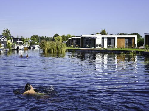 een persoon die zwemt in een waterlichaam bij Holiday Home MarinaPark Nieuw Loosdrecht-1 by Interhome in Loosdrecht