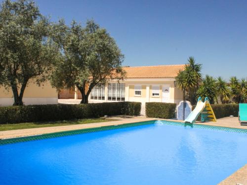 a swimming pool with a slide in front of a house at Holiday Home Quinta Dahlia by Interhome in Pegões