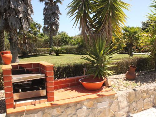 a brick oven in a garden with a palm tree at Holiday Home Quinta Dahlia by Interhome in Pegões