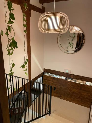 a staircase with a pendant light and a mirror at La Casa del Cantero in Pinilla del Valle