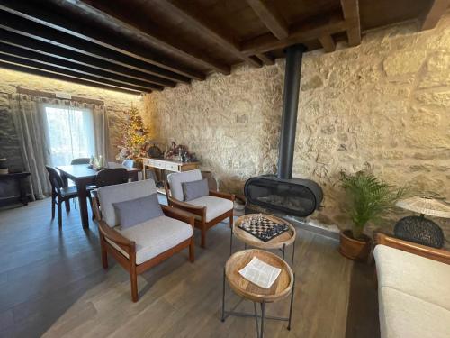 a living room with a fireplace and a table and chairs at La Casa del Cantero in Pinilla del Valle