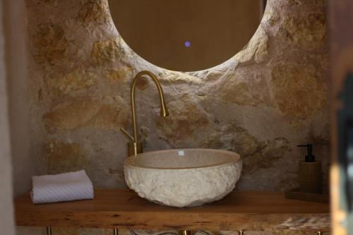 a bathroom with a bowl sink and a mirror at La Casa del Cantero in Pinilla del Valle