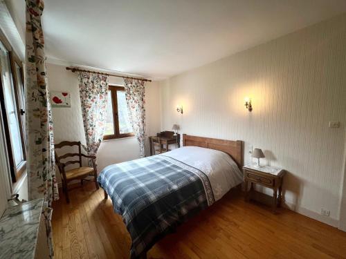 ein Schlafzimmer mit einem Bett, einem Stuhl und einem Fenster in der Unterkunft Gîte Saulxures-sur-Moselotte, 4 pièces, 6 personnes - FR-1-589-145 in Saulxures-sur-Moselotte