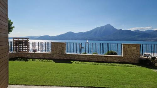 balcón con vistas al agua y a las montañas en Attilio High Living Suites - Adults Only en Torri del Benaco