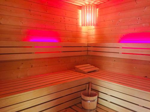 a wooden sauna with red and purple lights in it at Hotel Schützenhof mit Klimaanlage in Bürstadt