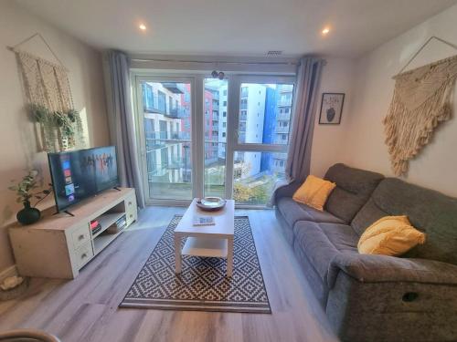 a living room with a couch and a tv at Modern 2Bed 2Bath with Balcony next to DLR Station in London
