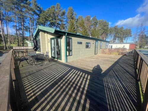 a shadow of a person standing on a deck at Pinehurst, 65 Golf View Lodge in Jedburgh