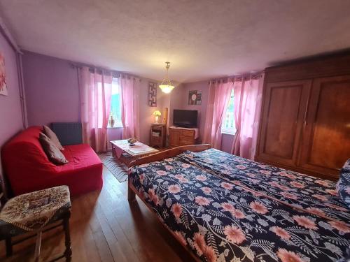 - une chambre avec un lit et un canapé rouge dans l'établissement Gîte paisible avec garage, terrasse et Wifi près du lac de Gérardmer - FR-1-589-159, à Gérardmer