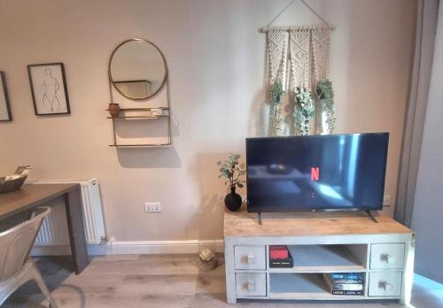 a living room with a tv on a entertainment center at Modern 2Bed 2Bath with Balcony next to DLR Station in London