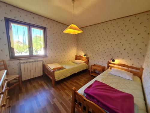 a bedroom with two beds and a window at Maison tranquille avec cheminée près de Gérardmer - FR-1-589-142 in Gerbépal
