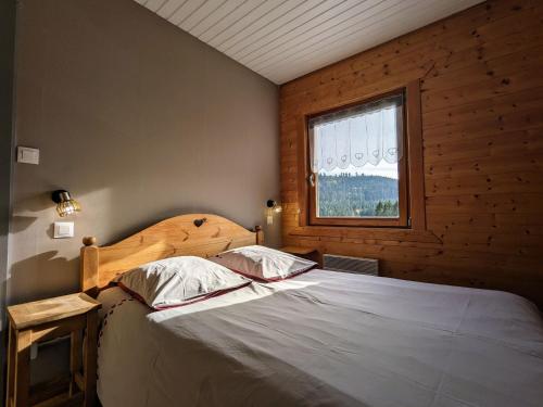 a bedroom with a large bed in a room with a window at Chalet rénové proche du Valtin – Idéal pour famille, randonnées et ski, Wifi, luges fournies - FR-1-589-150 in Ban-sur-Meurthe-Clefcy