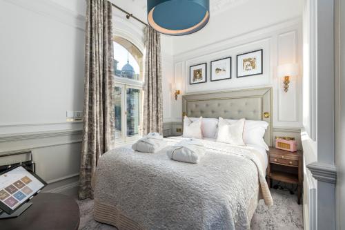 a bedroom with a large bed with a window at RÌGH Residences - George Street in Edinburgh