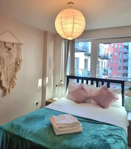 a bedroom with a bed with a towel on it at Modern 2Bed 2Bath with Balcony next to DLR Station in London