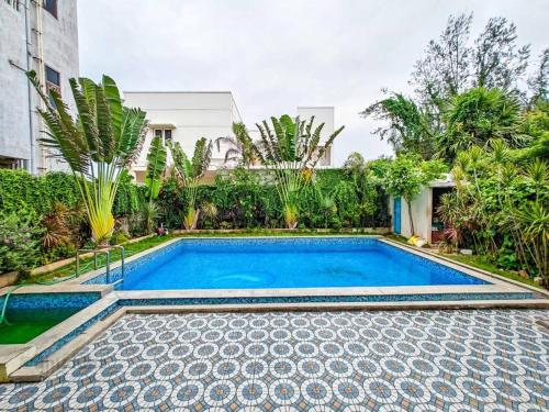 a swimming pool in the backyard of a house at Royal Experiences Buddha Sea View Villa, Mutukadu Beach ECR Chennai in Chennai