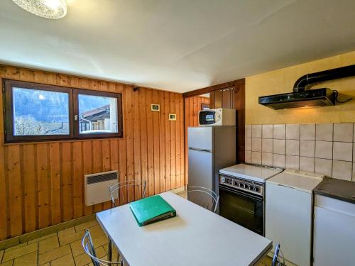 Il comprend une cuisine équipée d'une table blanche et d'un réfrigérateur. dans l'établissement Gîte cosy à La Bresse - Proche sentiers, rivière et piste cyclable, idéal pour randonnées et séjours en famille - FR-1-589-168, à La Bresse