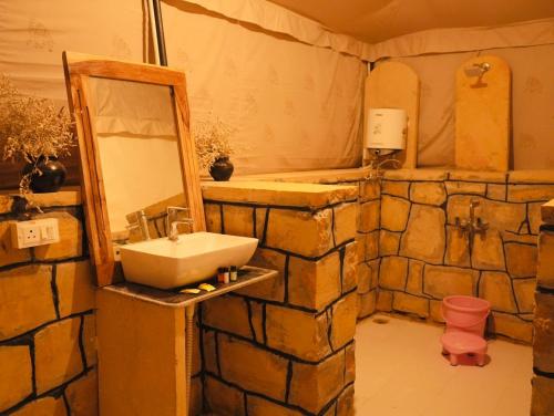 a bathroom with a sink and a mirror at Venture Desert Camp Jaisalmer in Sām