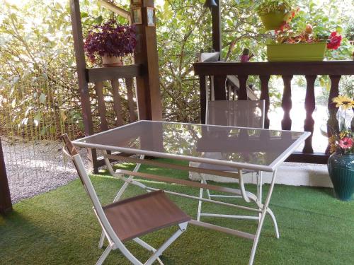 une table en verre et une chaise sur la terrasse dans l'établissement Gîte chaleureux avec terrasse, proche des activités touristiques et nature des Vosges - FR-1-589-177, à Saint-Dié-des-Vosges