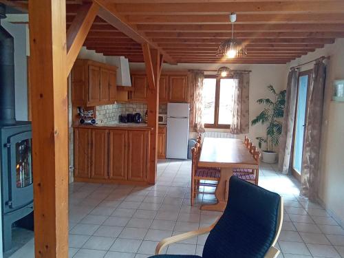 une cuisine avec une table et une salle à manger dans l'établissement Chalet spacieux avec cheminée, proche forêt, sentiers pédestres, terrasse, terrain clos, jeux et WIFI - FR-1-589-187, à Gerbamont 
