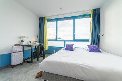 マルセイユにあるMontempô Marseille Centre Dômeのベッドと机と窓のある寝室