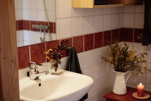 baño con lavabo y jarrón de flores en Formoseter, en Høvringen