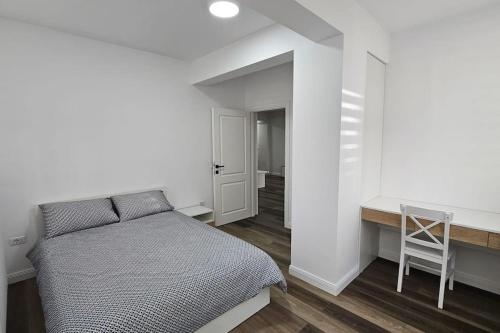 een witte slaapkamer met een bed en een bureau bij Nordic Residence 5 in Suceava