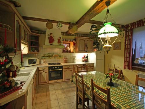 une cuisine avec une table et une salle à manger dans l'établissement Gîte chaleureux avec cheminée, jardin, proche des randonnées Vosgiennes et attractions Alsaciennes - FR-1-589-224, à Provenchères-sur-Fave