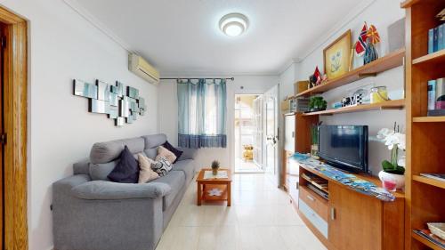 uma sala de estar com um sofá e uma televisão em bungalow lux playa gran Alacant em Gran Alacant