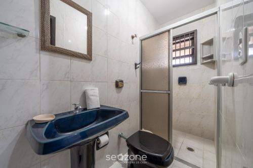 a bathroom with a blue sink and a toilet at Casa a 100m da praia em Barra Velha AIA2200 in Barra Velha