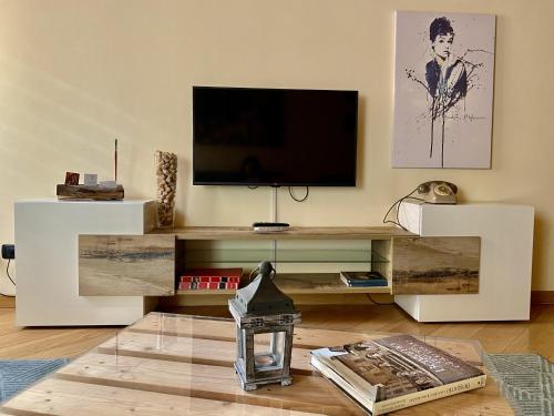 uma sala de estar com televisão num centro de entretenimento branco em House of artist em Bérgamo