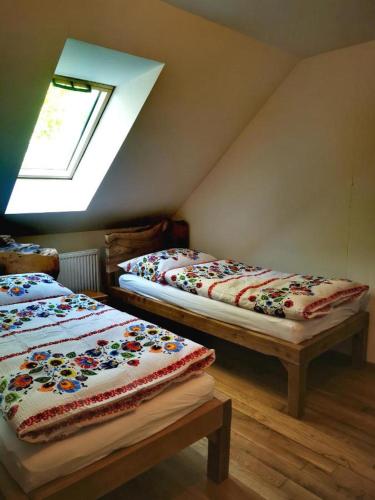 two beds sitting in a room with a skylight at Koliba Senica in Senica