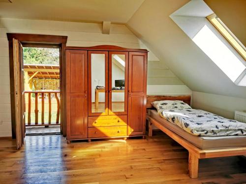 a attic room with a bed and a cabinet at Koliba Senica in Senica