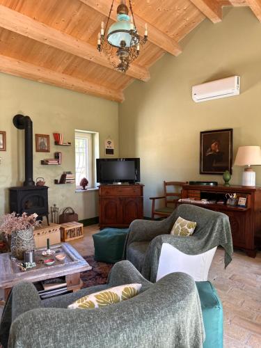 salon z kanapą, krzesłami i telewizorem w obiekcie Cascina La Vigna Country House w mieście Citta' Sant'Angelo