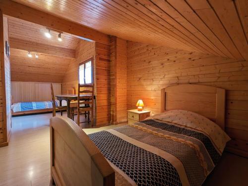 a bedroom with a bed in a wooden cabin at Gîte Vagney, 4 pièces, 6 personnes - FR-1-589-247 in Vagney