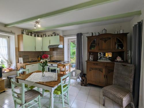 une cuisine avec une table et des chaises dans une pièce dans l'établissement Gîte cosy 