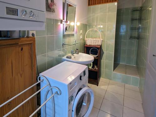 y baño con lavadora y lavamanos. en Gîte Saulcy-sur-Meurthe, 3 pièces, 4 personnes - FR-1-589-256 en Saulcy-sur-Meurthe