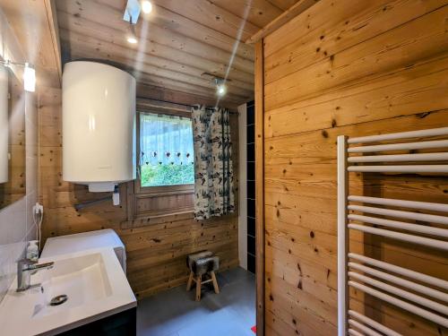 La salle de bains est pourvue de murs en bois, d'un lavabo et d'une fenêtre. dans l'établissement Beau gîte rénové près de La Bresse-Hohneck avec terrasse et parking - FR-1-589-264, à La Bresse