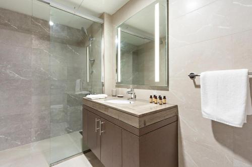 a bathroom with a sink and a shower at Silkhaus Modern 1BDR in Najmat Near Reem Central Park in Abu Dhabi