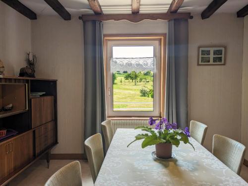 une salle à manger avec une table et une fenêtre dans l'établissement Gîte familial avec jardin, cheminée et parking à Jussarupt, près de Gérardmer - FR-1-589-320, à Jussarupt